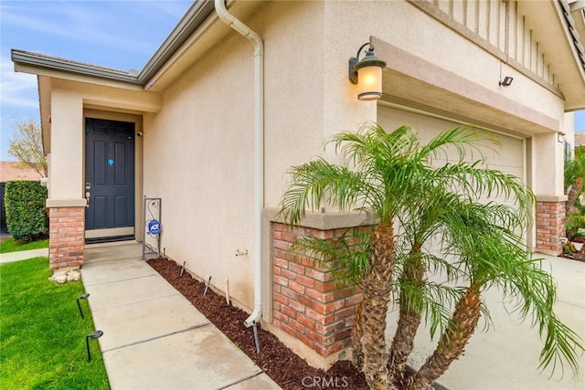 17963 Passionflower Ln, San Bernardino, CA 92407 - property entrance featuring stucco siding, a garage, and driveway