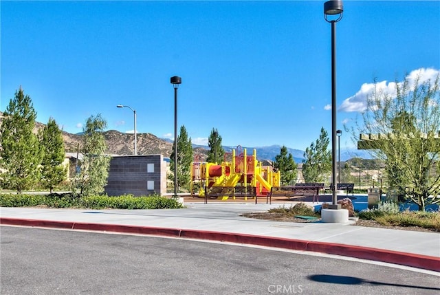 17963 Passionflower Ln, San Bernardino, CA 92407 - view of asphalt street with street lights, sidewalks, and a mountain view