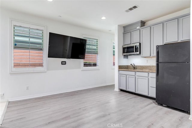 17963 Passionflower Ln, San Bernardino, CA 92407 - kitchen with freestanding refrigerator, stainless steel microwave, gray cabinets, light wood-style flooring, and recessed lighting
