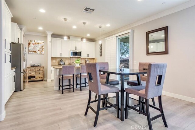 17963 Passionflower Ln, San Bernardino, CA 92407 - dining area featuring ornamental molding, light wood-type flooring, recessed lighting, and baseboards