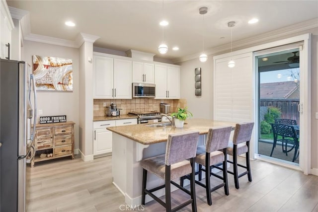 17963 Passionflower Ln, San Bernardino, CA 92407 - kitchen with appliances with stainless steel finishes, a sink, crown molding, tasteful backsplash, and light wood-type flooring
