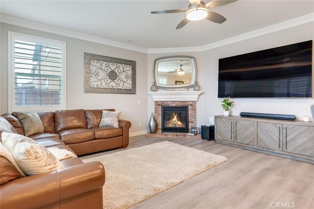 17963 Passionflower Ln, San Bernardino, CA 92407 - living area featuring ornamental molding, light wood-style floors, a ceiling fan, a glass covered fireplace, and baseboards