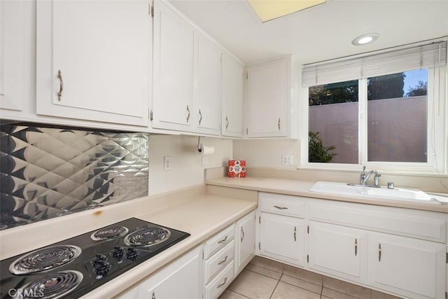 321 Avenida Carmel Unit H, Laguna Woods, CA 92637 - kitchen with white cabinets, black electric stovetop, a sink, and light tile patterned floors