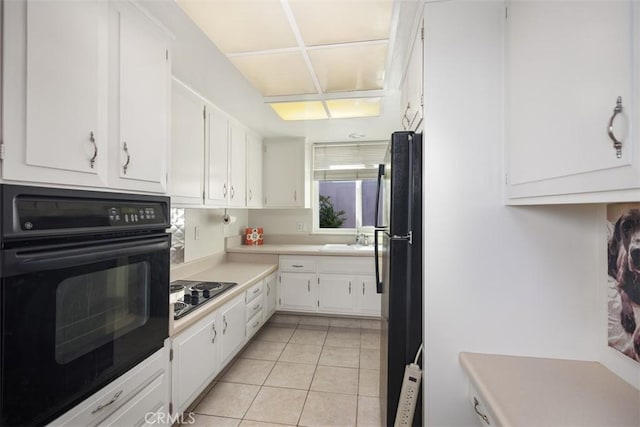 321 Avenida Carmel Unit H, Laguna Woods, CA 92637 - kitchen featuring white cabinets, a sink, light tile patterned flooring, light countertops, and black appliances