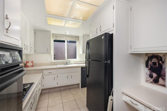 321 Avenida Carmel Unit H, Laguna Woods, CA 92637 - kitchen with white cabinets, light countertops, light tile patterned floors, a sink, and black appliances