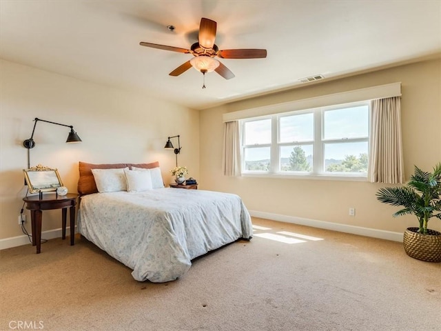 carpeted bedroom with baseboards, a ceiling fan, and visible vents