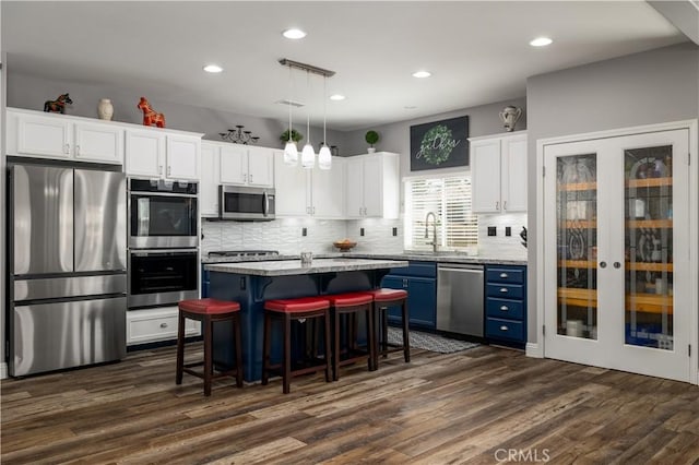 29465 Siderite Cir, Menifee, CA 92584 - kitchen featuring stainless steel appliances, blue cabinets, a sink, dark wood-style floors, and white cabinetry