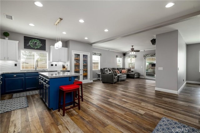 29465 Siderite Cir, Menifee, CA 92584 - kitchen with blue cabinets, white cabinets, backsplash, a kitchen island, and recessed lighting