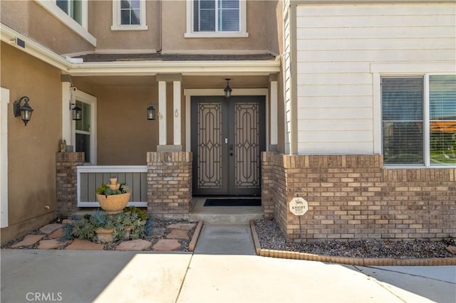 29465 Siderite Cir, Menifee, CA 92584 - view of exterior entry featuring stucco siding, covered porch, and brick siding