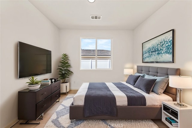 bedroom featuring visible vents, baseboards, and light wood-style floors