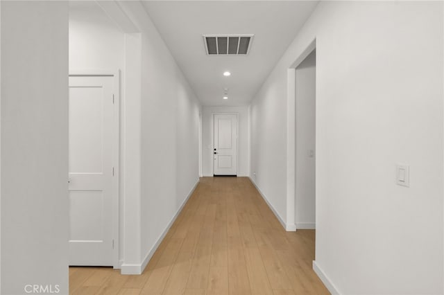 corridor featuring light wood-style floors, recessed lighting, visible vents, and baseboards