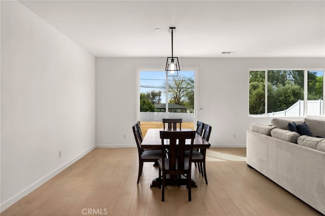 dining space with visible vents, baseboards, and light wood-type flooring