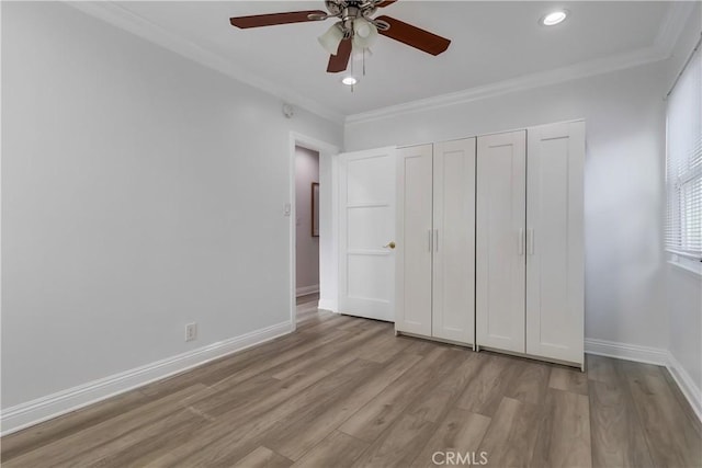 unfurnished bedroom featuring a closet, ornamental molding, recessed lighting, wood finished floors, and baseboards