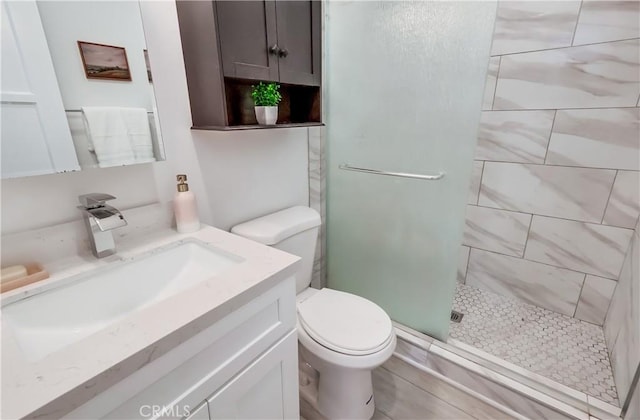 full bath with toilet, a shower stall, and vanity