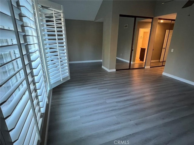 spare room featuring baseboards and wood finished floors