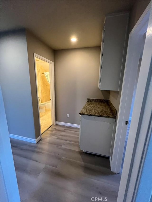 hall featuring recessed lighting, light wood-type flooring, and baseboards