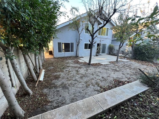 back of house with a patio area, stucco siding, and fence