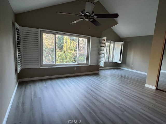 interior space with wood finished floors, ceiling fan, baseboards, and vaulted ceiling