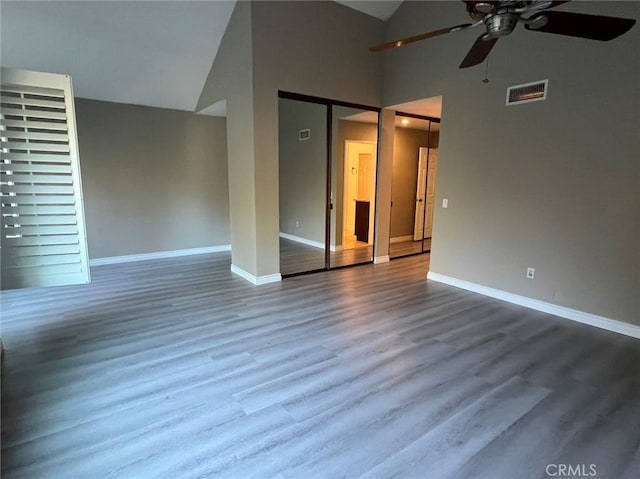 interior space featuring high vaulted ceiling, ceiling fan, visible vents, wood finished floors, and baseboards