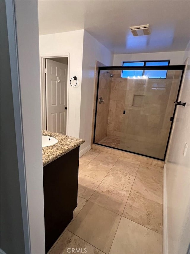 bathroom with a shower stall, vanity, tile patterned flooring, visible vents, and baseboards