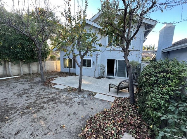 back of house with a patio area, a fenced backyard, and stucco siding