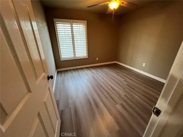unfurnished room featuring ceiling fan, baseboards, and dark wood-style floors