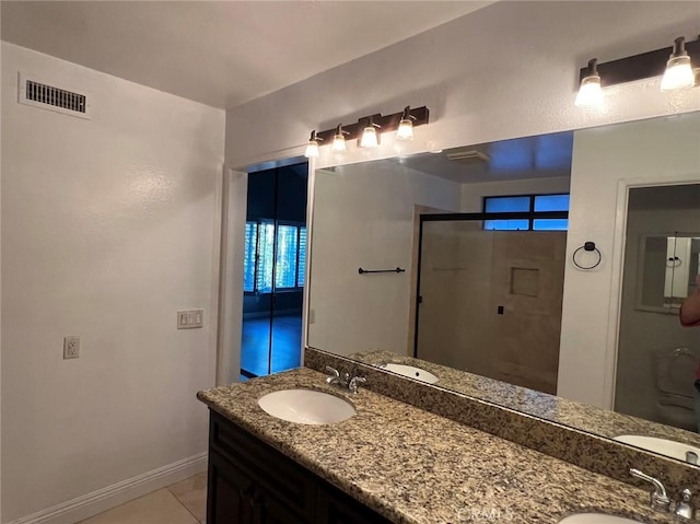 bathroom featuring a stall shower, a sink, visible vents, and tile patterned floors