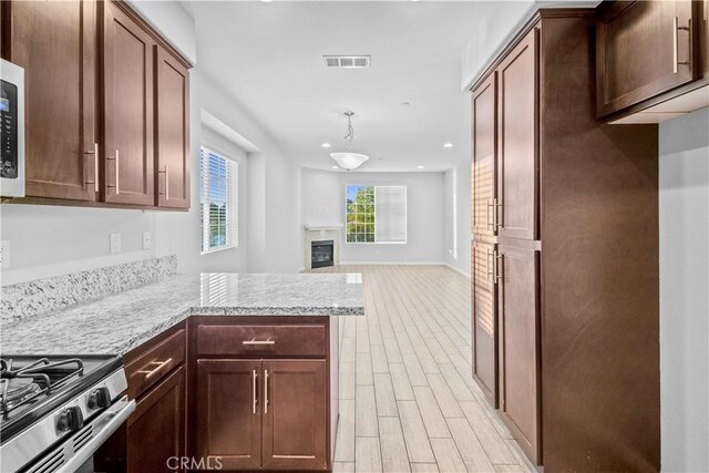 4619 Alekona Ct, Cypress, CA 90630 - kitchen featuring a glass covered fireplace, light wood-style flooring, a peninsula, recessed lighting, and light stone countertops