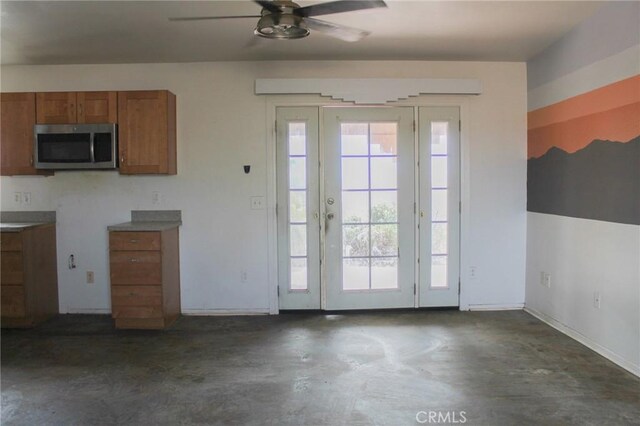 1471 Luna Mesa Rd, Yucca Valley, CA 92284 - kitchen featuring stainless steel microwave, brown cabinets, a ceiling fan, concrete floors, and baseboards