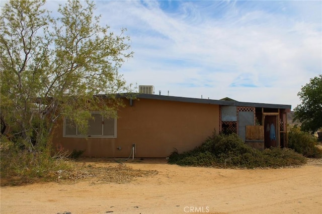 view of property exterior with central air condition unit and stucco siding