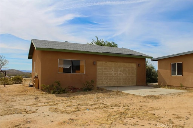 view of property exterior featuring an attached garage and stucco siding