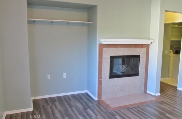 unfurnished living room featuring a tile fireplace, baseboards, and wood finished floors