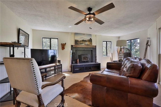 23677 Crest Forest Dr, Crestline, CA 92325 - living area with ceiling fan, wood finished floors, a textured ceiling, and baseboards