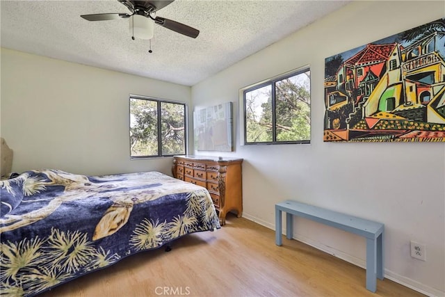 23677 Crest Forest Dr, Crestline, CA 92325 - bedroom featuring wood finished floors, a textured ceiling, multiple windows, and baseboards