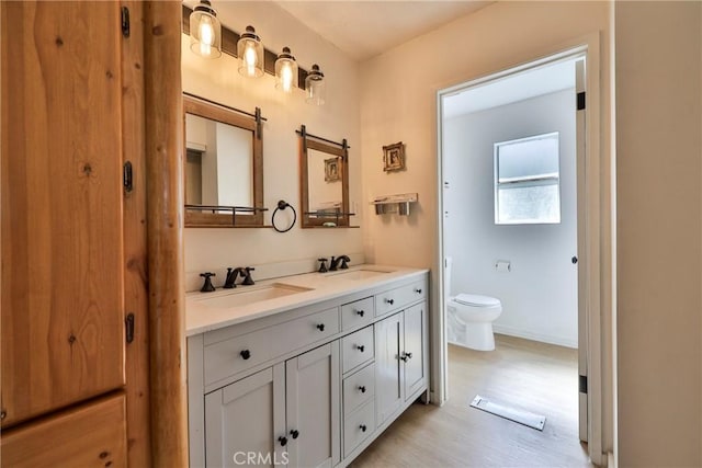 23677 Crest Forest Dr, Crestline, CA 92325 - bathroom with double vanity, toilet, wood finished floors, and baseboards
