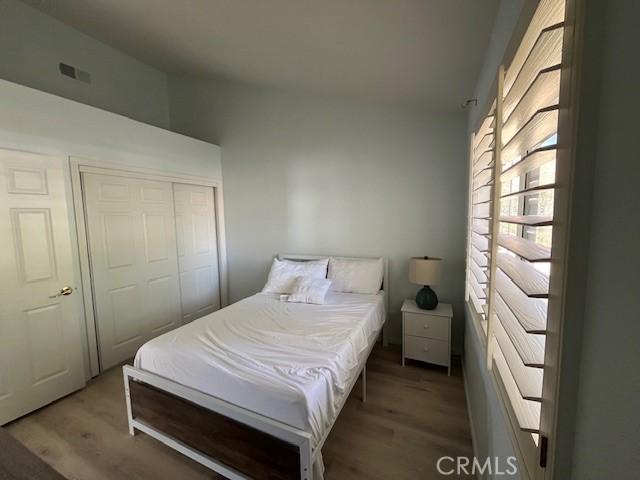 bedroom featuring visible vents, wood finished floors, and a closet