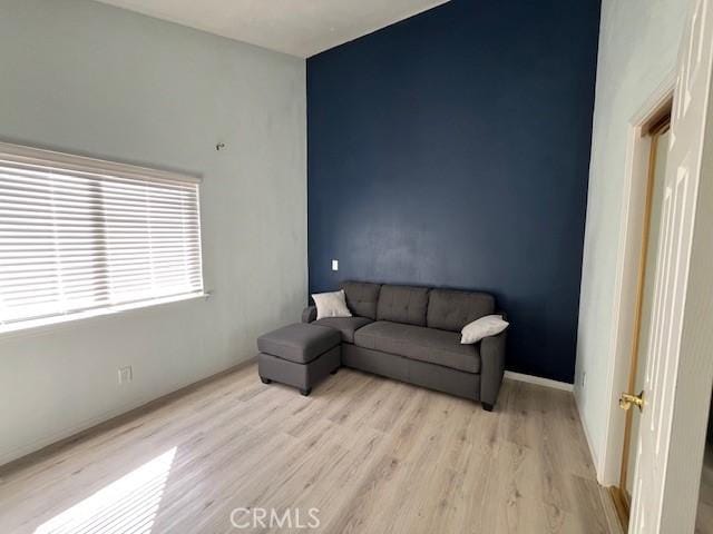 living area with light wood-style floors and baseboards