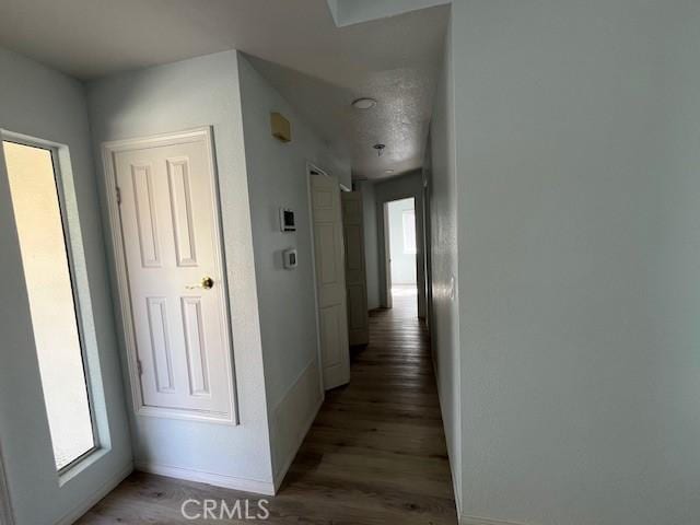 hallway with light wood-style flooring and baseboards