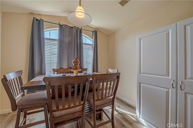 dining area with baseboards, visible vents, and light wood-style flooring