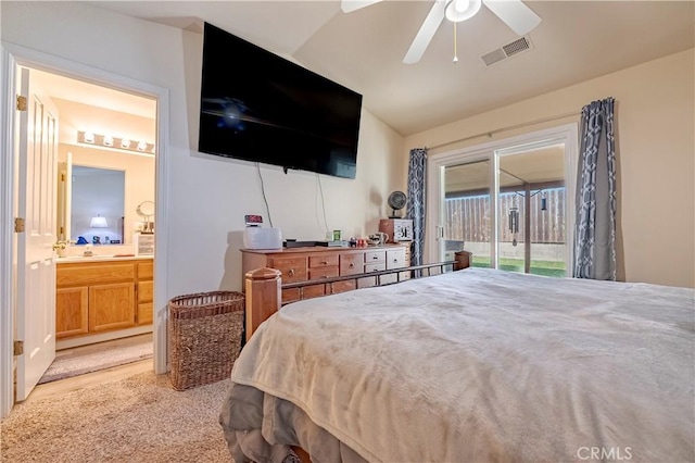 bedroom with visible vents, access to exterior, a ceiling fan, ensuite bath, and vaulted ceiling