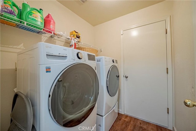 laundry area featuring laundry area, wood finished floors, and washing machine and clothes dryer
