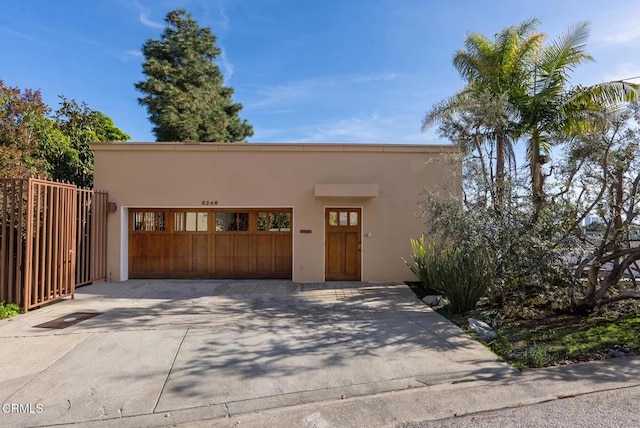 8246 Woodshill Trl, Los Angeles, CA 90069 - view of front facade featuring stucco siding, concrete driveway, and an attached garage