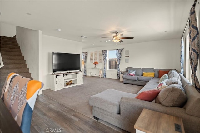 living room with visible vents, baseboards, a ceiling fan, wood finished floors, and stairs