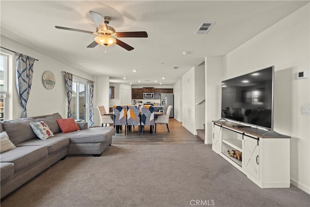 carpeted living room with baseboards, a ceiling fan, visible vents, and recessed lighting