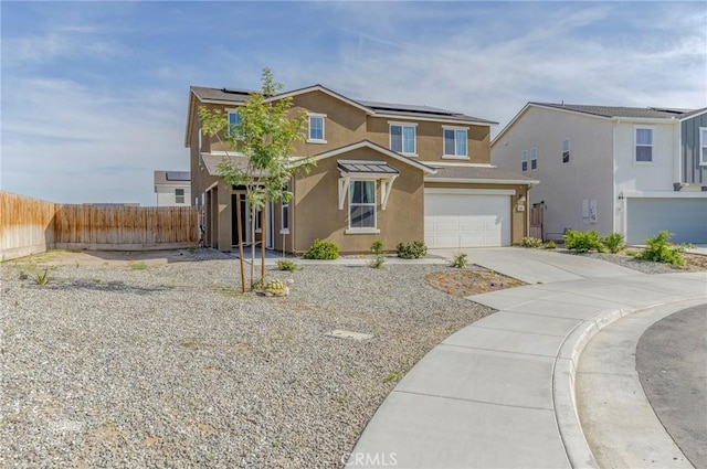 traditional home featuring fence, solar panels, a garage, and stucco siding