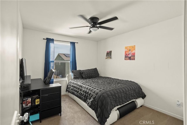 carpeted bedroom featuring baseboards and a ceiling fan