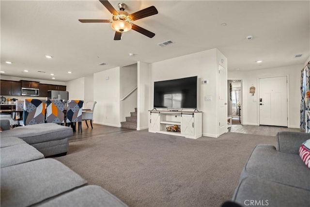 living room with recessed lighting, baseboards, visible vents, and stairway