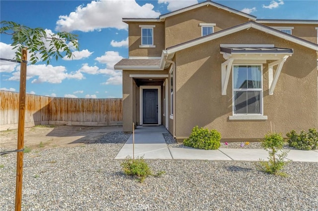 view of front of home featuring fence and stucco siding