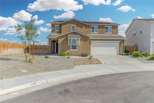 traditional-style house with fence, a garage, driveway, and stucco siding