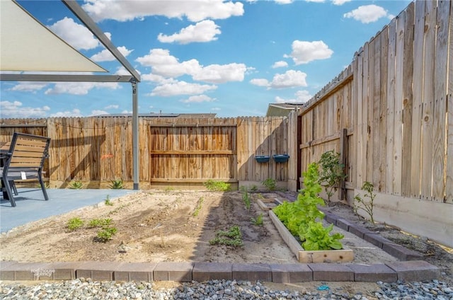 view of yard featuring a fenced backyard, a vegetable garden, and a patio